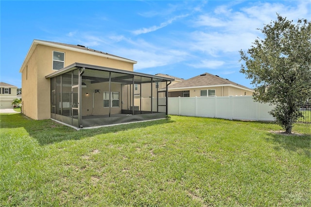 rear view of property with a sunroom and a lawn