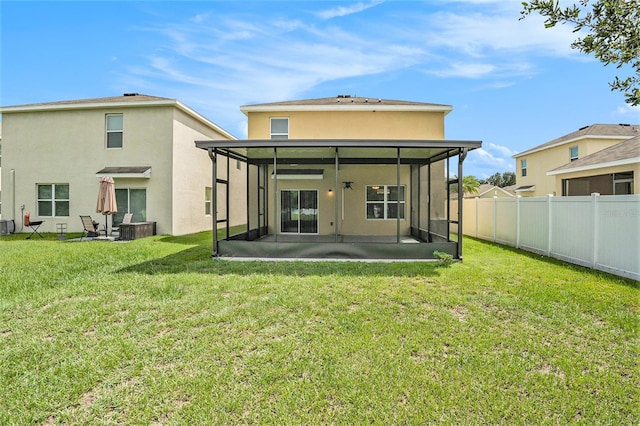 rear view of property with a yard, ceiling fan, a patio area, and a sunroom