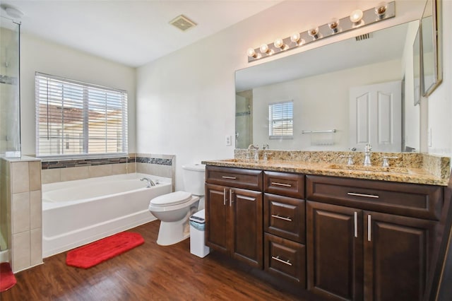 full bathroom with vanity, toilet, hardwood / wood-style floors, and plus walk in shower