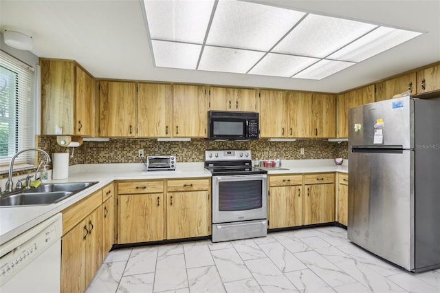 kitchen with marble finish floor, light countertops, a sink, and stainless steel appliances