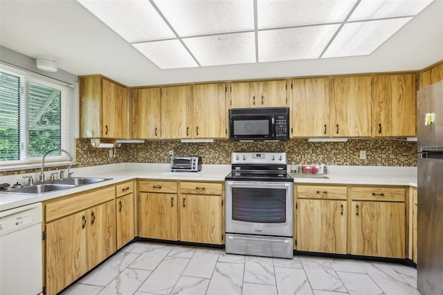 kitchen with marble finish floor, a sink, light countertops, and appliances with stainless steel finishes