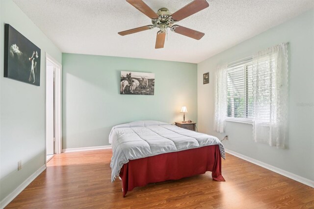 bedroom featuring ceiling fan, a textured ceiling, and hardwood / wood-style floors