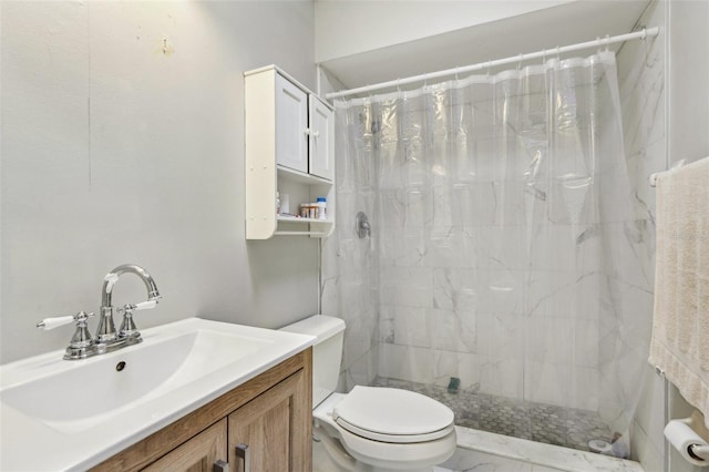 full bathroom with vanity, marble finish floor, toilet, and tiled shower