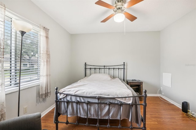 bedroom with baseboards, wood finished floors, and a ceiling fan