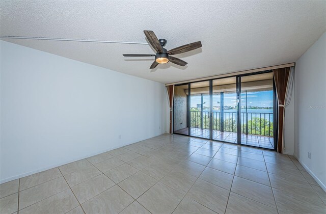 7037 Sunset Dr S Unit 602, South Pasadena, FL 33707 - spare room featuring a textured ceiling, light tile patterned flooring, floor to ceiling windows, and a ceiling fan