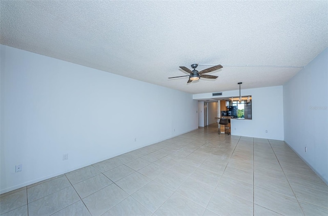 unfurnished living room with a textured ceiling, light tile patterned floors, and ceiling fan