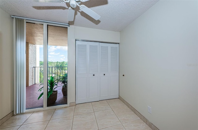 7037 Sunset Dr S Unit 602, South Pasadena, FL 33707 - unfurnished bedroom with a closet, light tile patterned floors, a textured ceiling, access to exterior, and a wall of windows