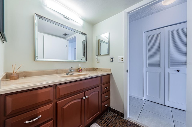 bathroom featuring vanity, a textured ceiling, and tile patterned floors