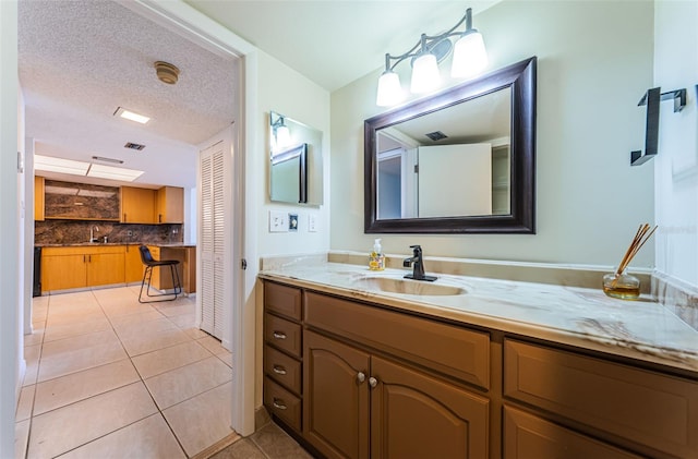 bathroom featuring a textured ceiling, vanity, tile patterned floors, and tasteful backsplash