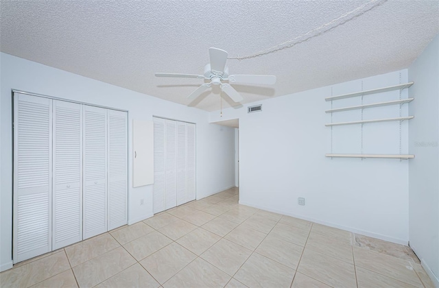 7037 Sunset Dr S Unit 602, South Pasadena, FL 33707 - unfurnished bedroom with a textured ceiling, a ceiling fan, visible vents, light tile patterned flooring, and multiple closets