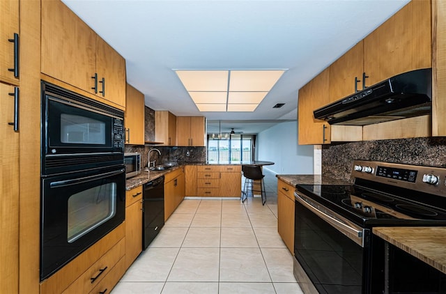 kitchen featuring sink, light tile patterned floors, backsplash, black appliances, and dark stone countertops