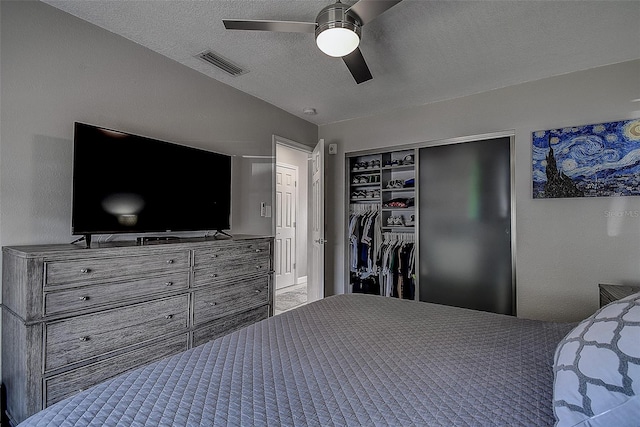 carpeted bedroom with a textured ceiling, ceiling fan, and a closet