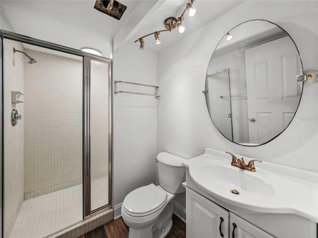 bathroom featuring vanity, hardwood / wood-style flooring, toilet, and a shower with shower door