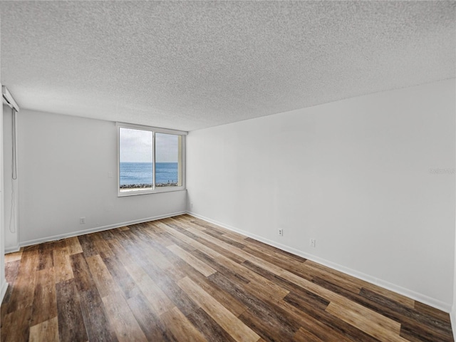 7100 Sunset Way Unit 405, St Pete Beach, FL 33706 - spare room featuring a textured ceiling, wood finished floors, and baseboards