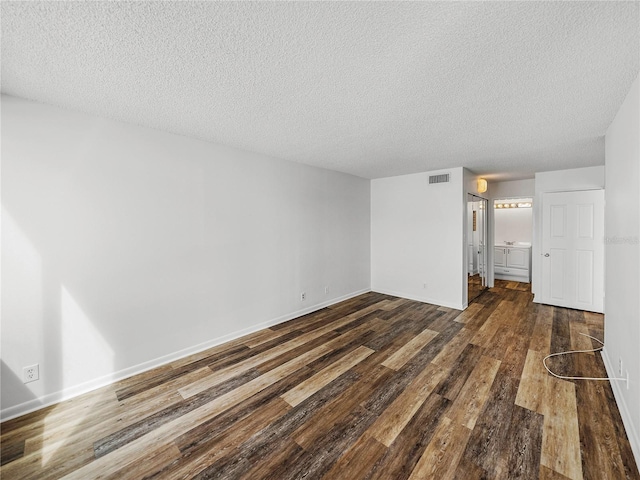 7100 Sunset Way Unit 405, St Pete Beach, FL 33706 - unfurnished living room with dark wood-type flooring, a textured ceiling, and baseboards
