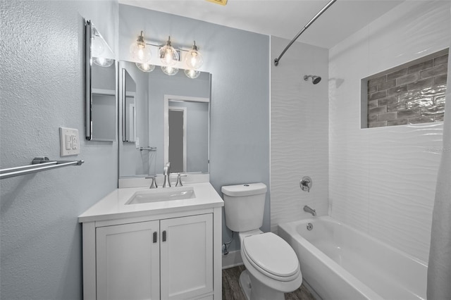 full bathroom featuring vanity, hardwood / wood-style floors, tiled shower / bath combo, and toilet