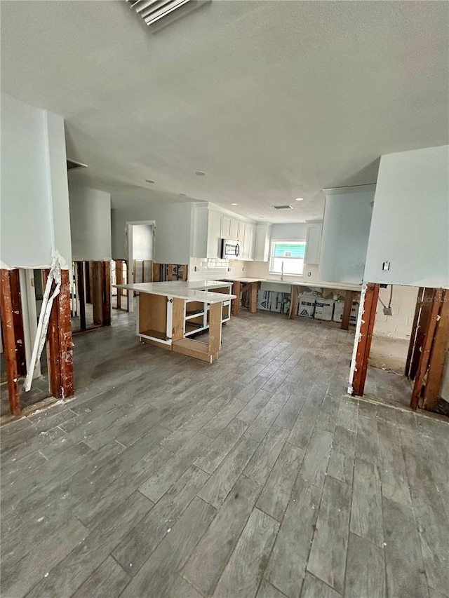 unfurnished living room with hardwood / wood-style flooring and sink