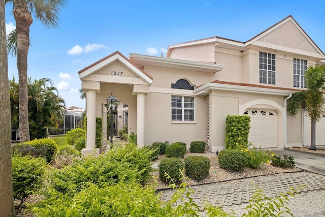 view of front of house with driveway, an attached garage, and stucco siding