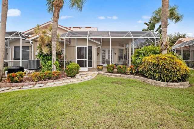 view of front of home featuring central air condition unit, a lanai, and a front lawn