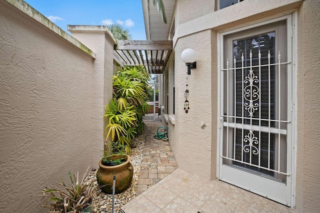 doorway to property featuring stucco siding