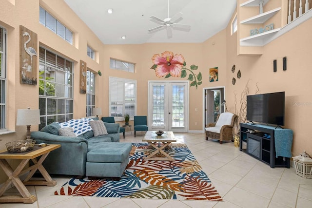 tiled living room featuring ceiling fan and a high ceiling