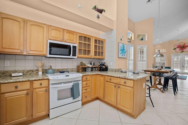 kitchen featuring kitchen peninsula, electric range, light stone countertops, and tasteful backsplash