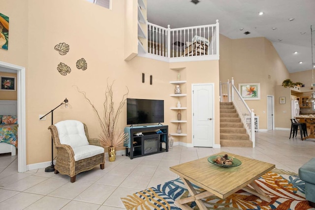 tiled living room with a high ceiling, baseboards, stairs, and built in features