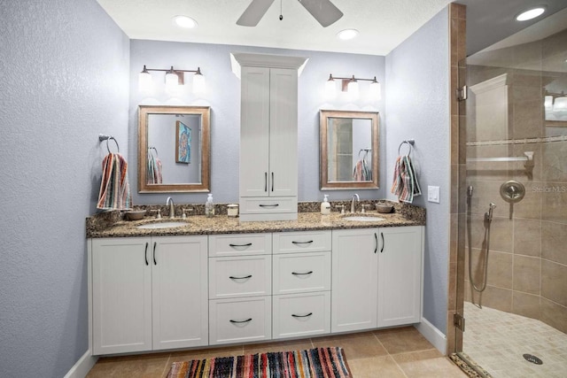 bathroom featuring vanity, ceiling fan, tile patterned floors, and a tile shower