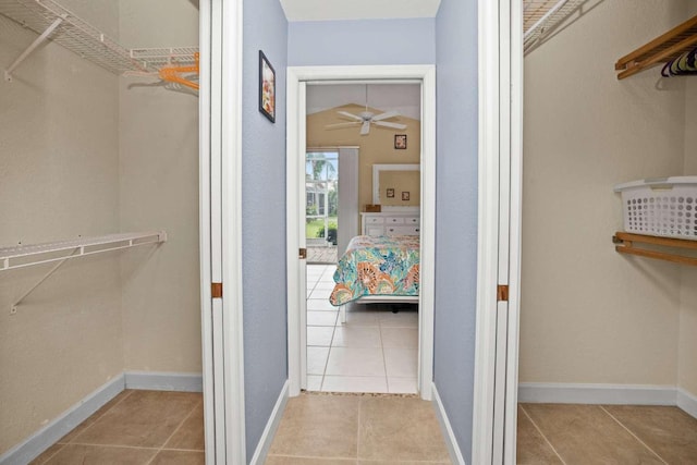 walk in closet with ceiling fan and tile patterned flooring