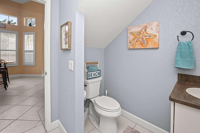 bathroom with vanity, toilet, tile patterned floors, and vaulted ceiling