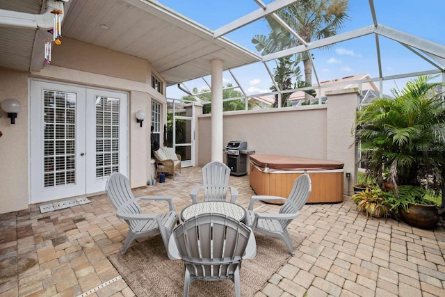 view of patio featuring area for grilling, a lanai, and a hot tub