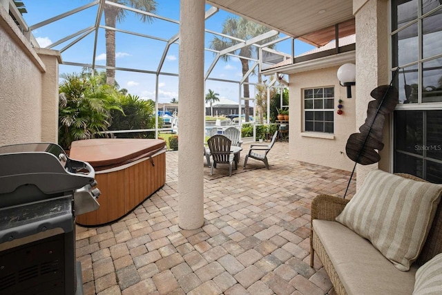 view of patio / terrace with a hot tub, glass enclosure, and grilling area