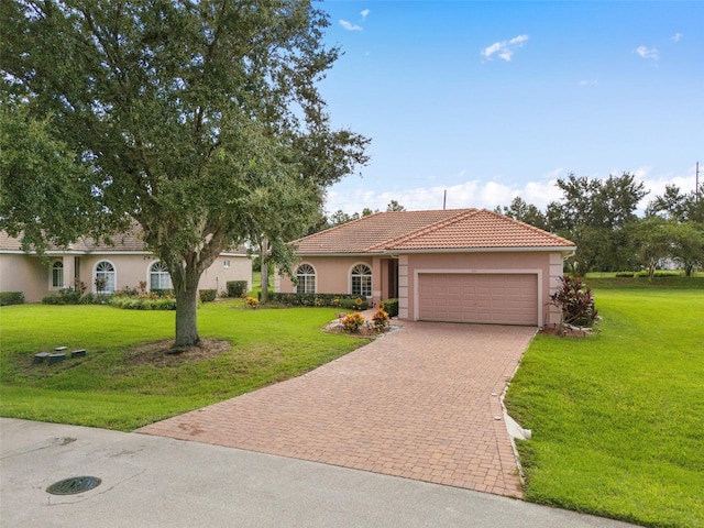 mediterranean / spanish house featuring a front yard and a garage