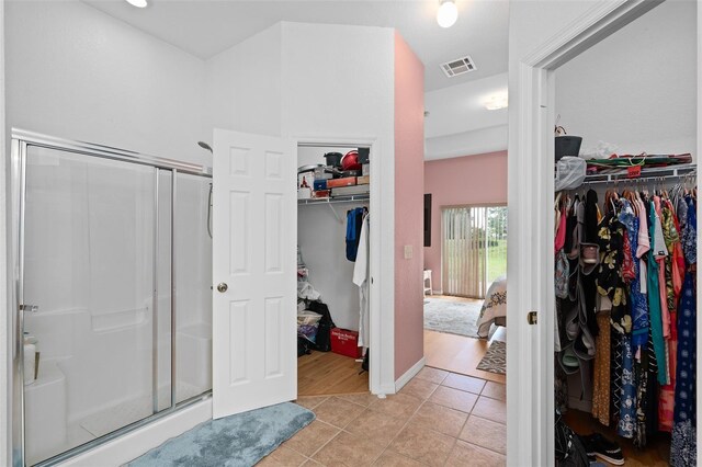 bathroom featuring a shower with shower door and tile patterned flooring