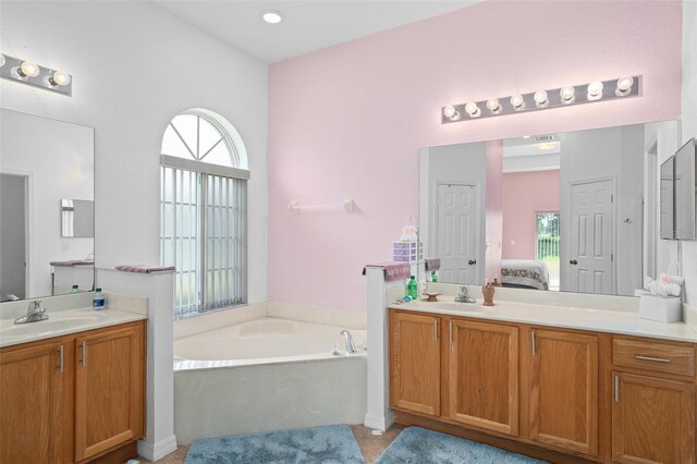 bathroom with a tub, a healthy amount of sunlight, and vanity