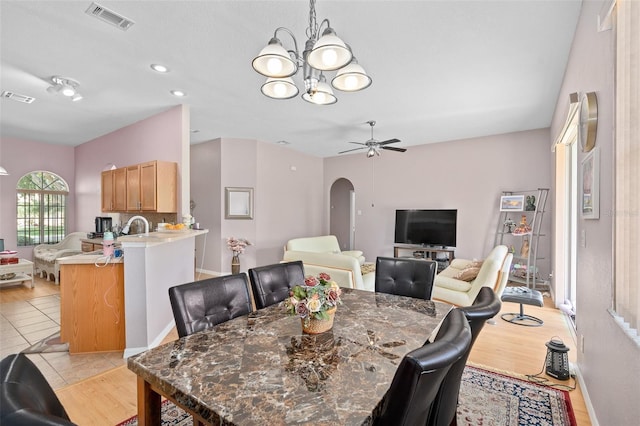 dining room featuring ceiling fan with notable chandelier and light hardwood / wood-style floors