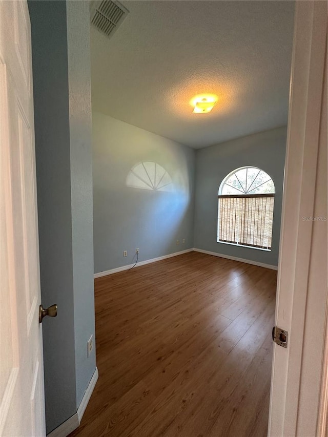 spare room with hardwood / wood-style flooring and a textured ceiling