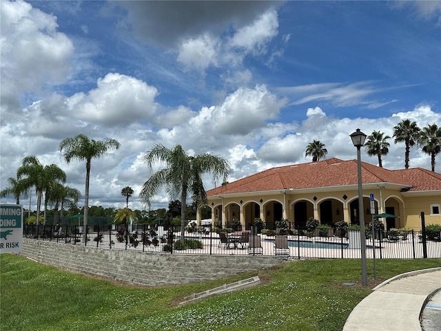 view of property's community featuring a lawn and a swimming pool