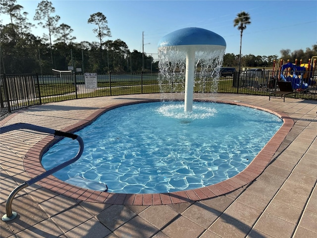 view of swimming pool with a playground