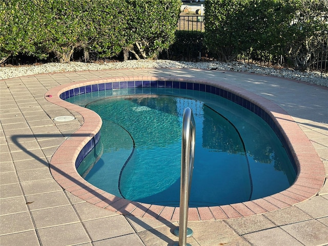 view of swimming pool featuring an in ground hot tub