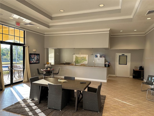 dining space with crown molding, light tile patterned floors, french doors, a high ceiling, and a raised ceiling