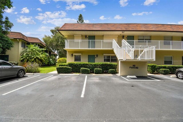 view of property with uncovered parking and stairs