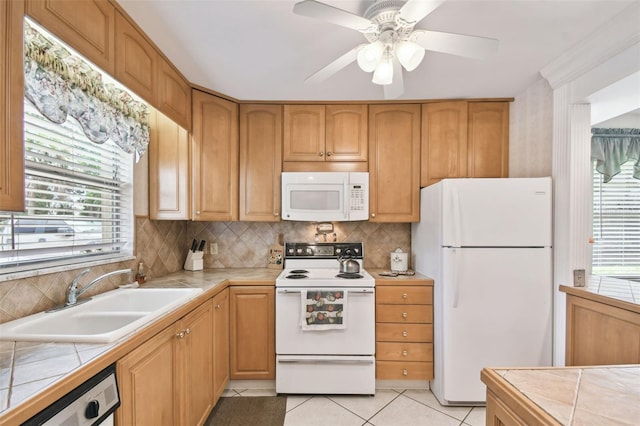 kitchen featuring white appliances, light tile patterned floors, tile counters, sink, and ceiling fan