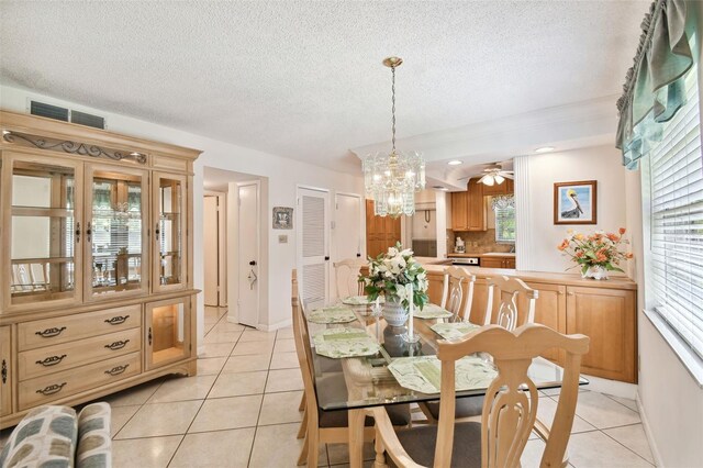 dining area with light tile patterned flooring, a chandelier, healthy amount of natural light, and a textured ceiling