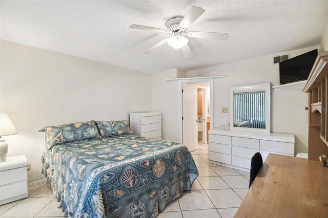 bedroom with light tile patterned flooring, ceiling fan, and ensuite bath