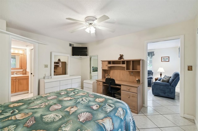 bedroom featuring sink, light tile patterned flooring, ceiling fan, connected bathroom, and a textured ceiling