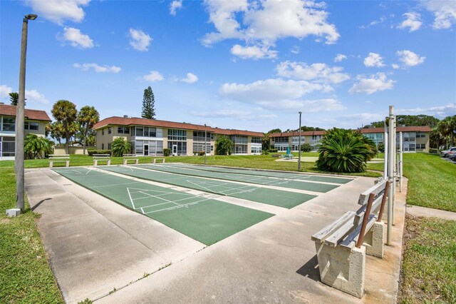 surrounding community with a yard, shuffleboard, and a residential view