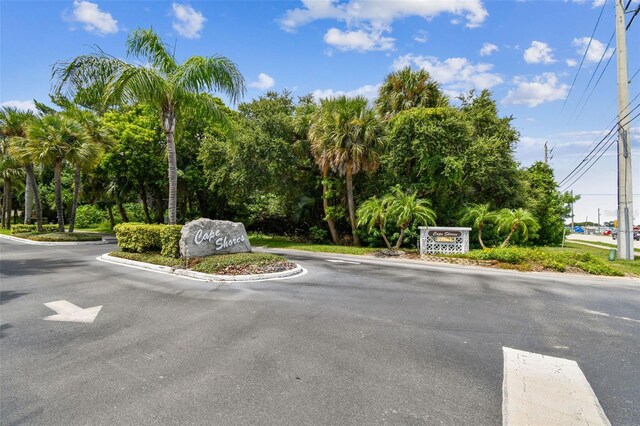view of asphalt street with curbs and view of wooded area