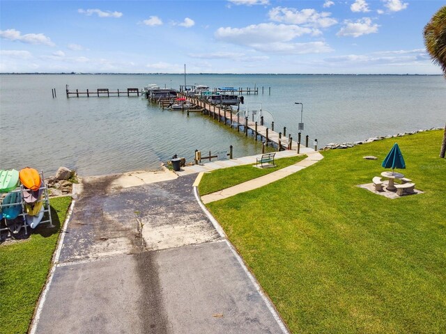dock featuring a water view, a lawn, and a boat ramp