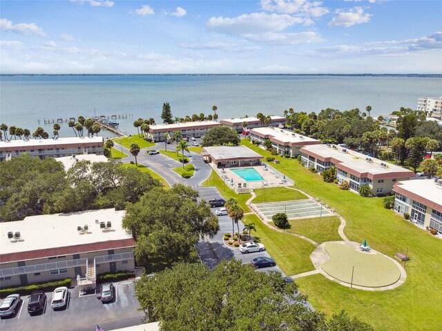 drone / aerial view of a nearby body of water and a pool area